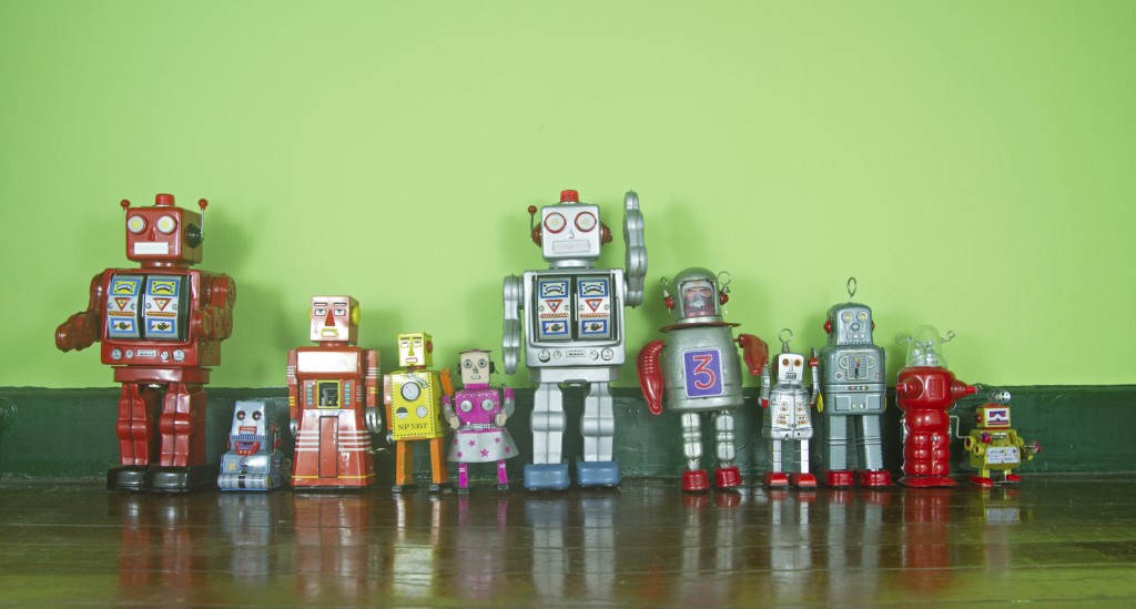 a line of retro robots on a wooden floor
