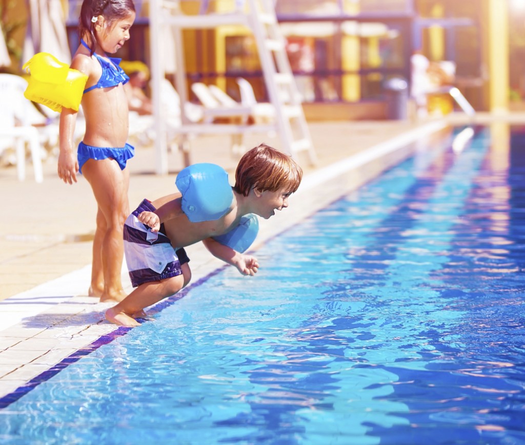 little boy jumping into the pool,
