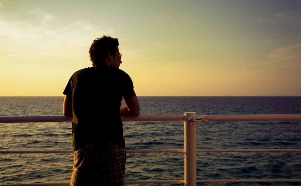 guy standing on a boat and looking at the sea