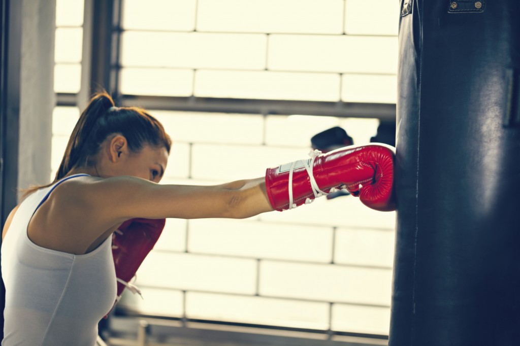a Female Punching A Bag With Boxing Gloves On