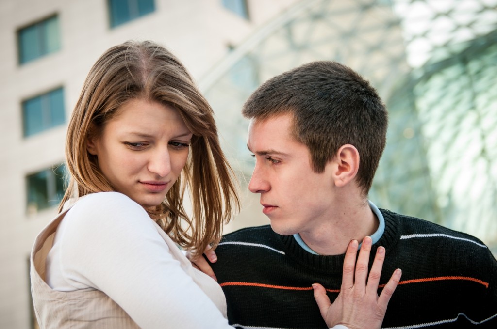 Lifestyle image of young woman refusing man outside on street having relationship problems