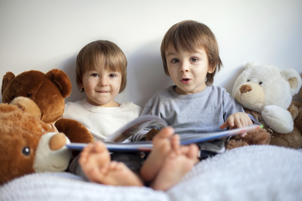 two little boys, reading a book, having fun