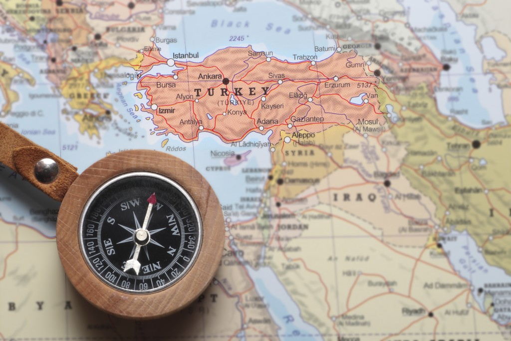 Compass on a map pointing at Turkey and planning a travel destination