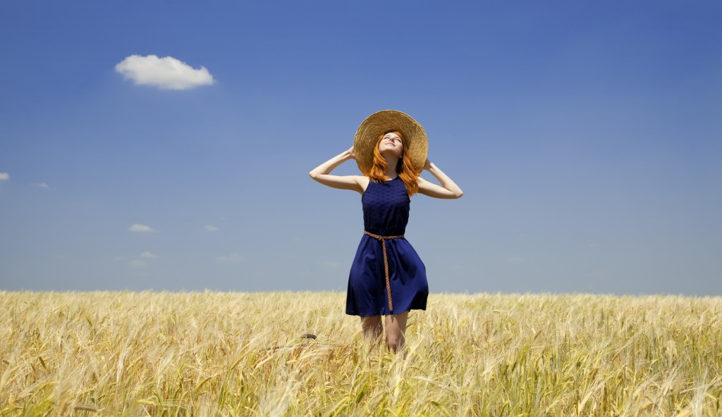 Redhead girl at spring wheat field.