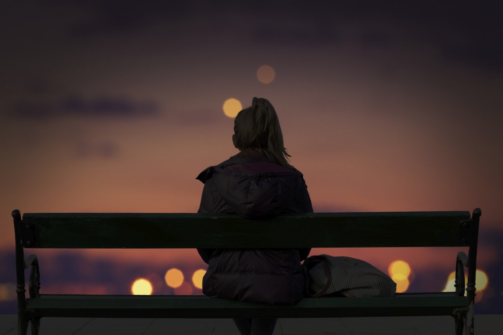 Silhouette of a girl watching defocused city lights