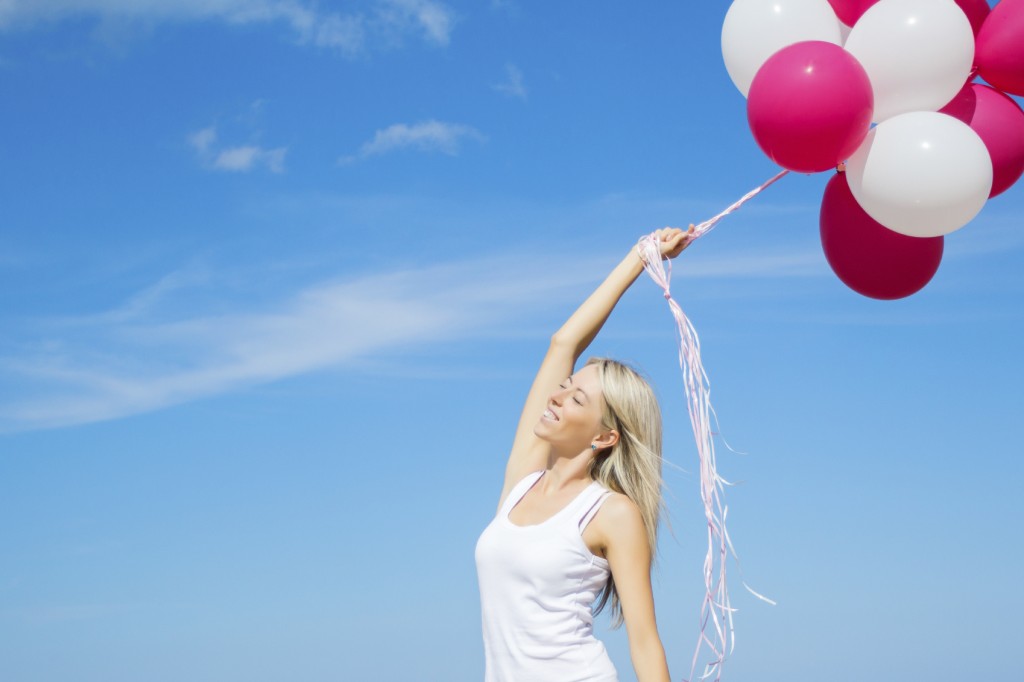 Happy woman holding balloons