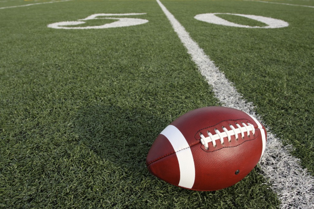 a football sitting on the 50 yard line.