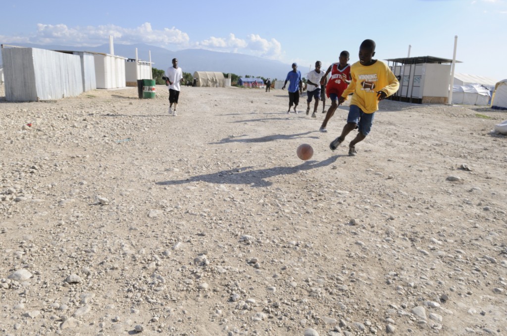 Haitian kids playing soccer outside.