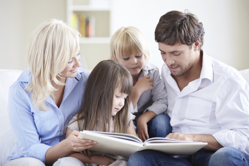 a family gathered around a book for story time.
