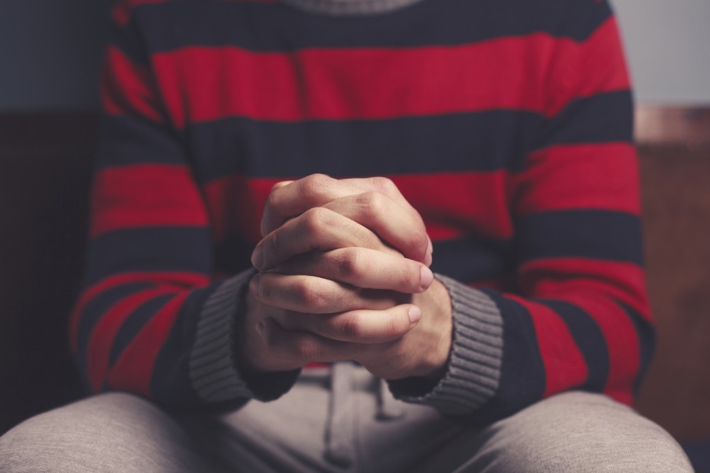 Closeup on a man with his hands folded in prayer