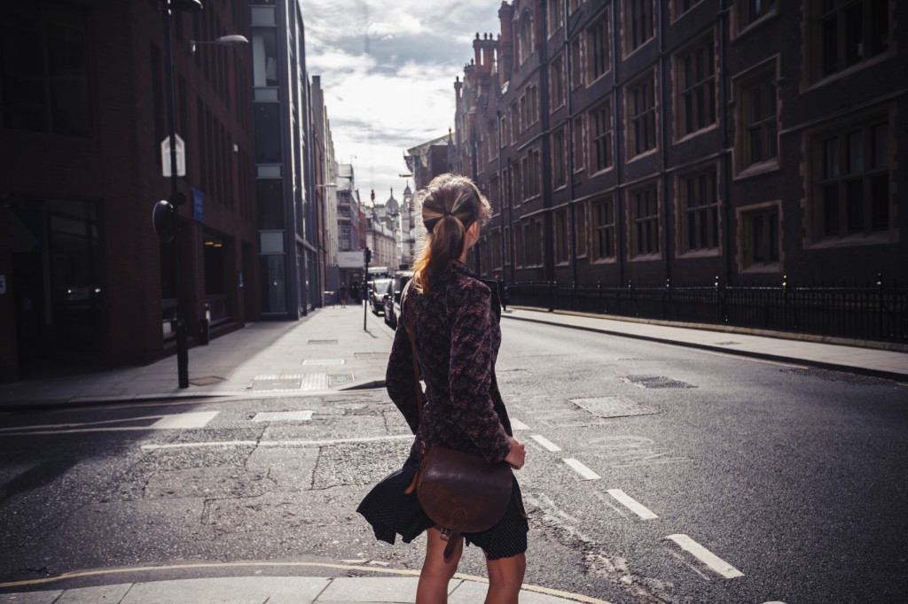 A young woman is walking along a city street.