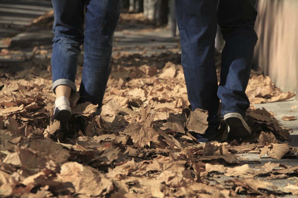 Young couple walking on the path full of leaves