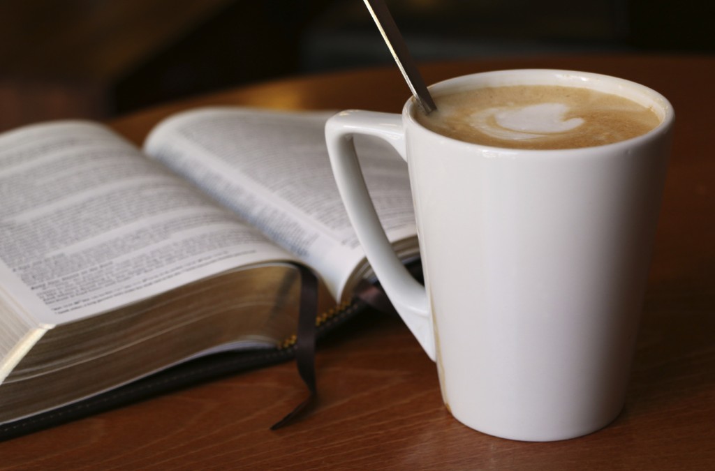 Bible opened to Luke with a cafe latte in a Coffee House.