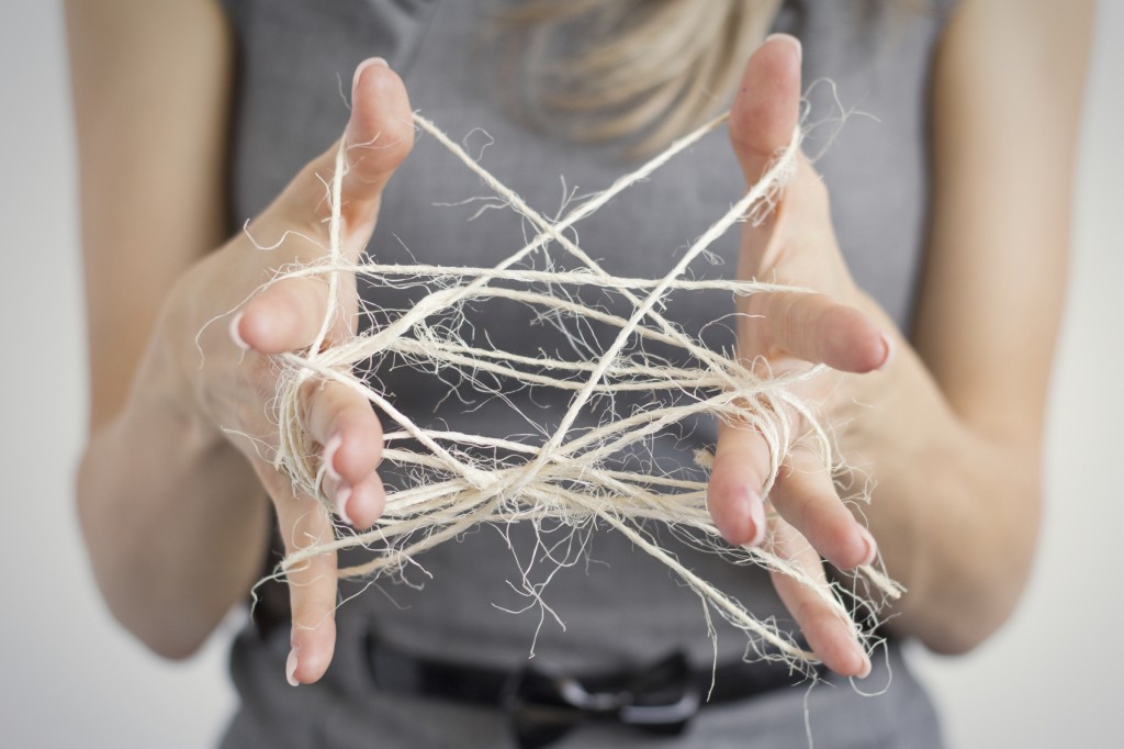 Woman making cats cradle out of twine
