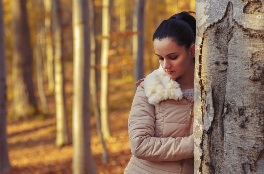 Sad woman in forest while autumn season
