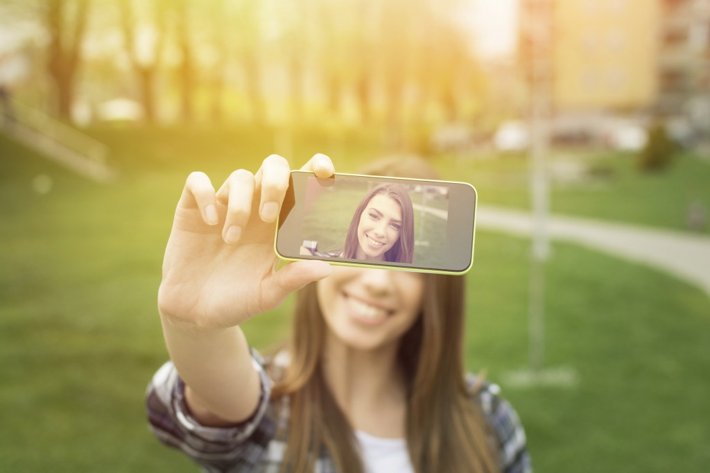 young woman taking a selfie with phone