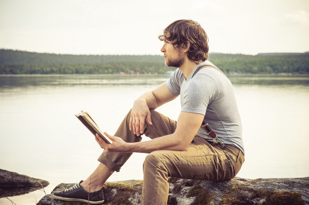 Young Man reading book outdoor Summer vacations Lifestyle