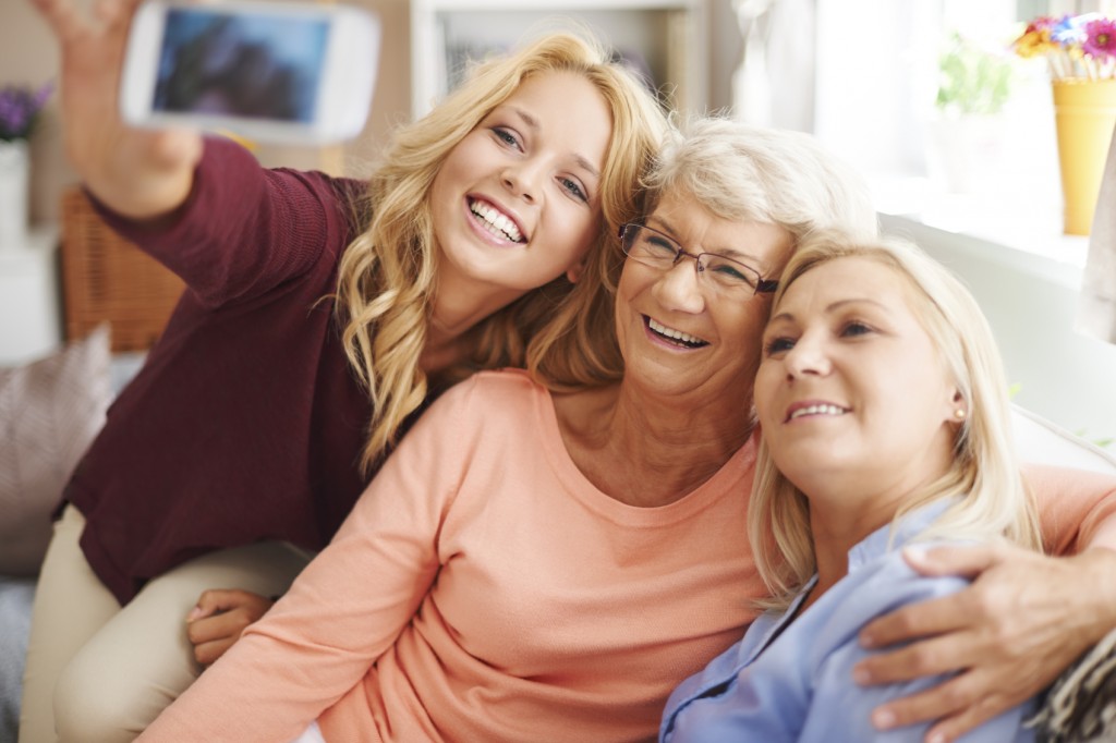 Blonde girl taking selfie with mom and grandma