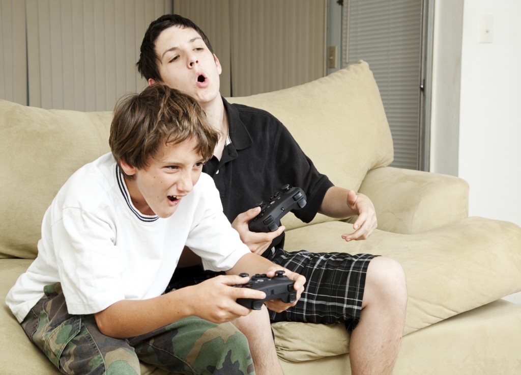 Two boys playing video games with intense competition.