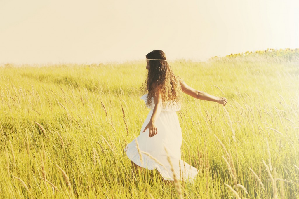 happy smiling woman in boho style clothes run through the field,