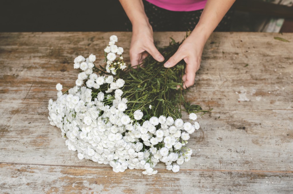 woman bundling white flowers
