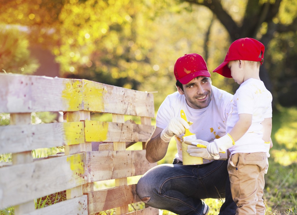 Father and son painting fence