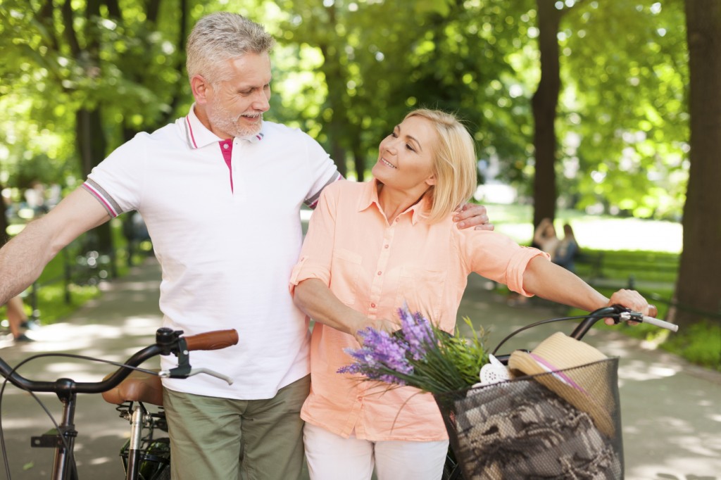 Mature couple spending time together at park with bicycles