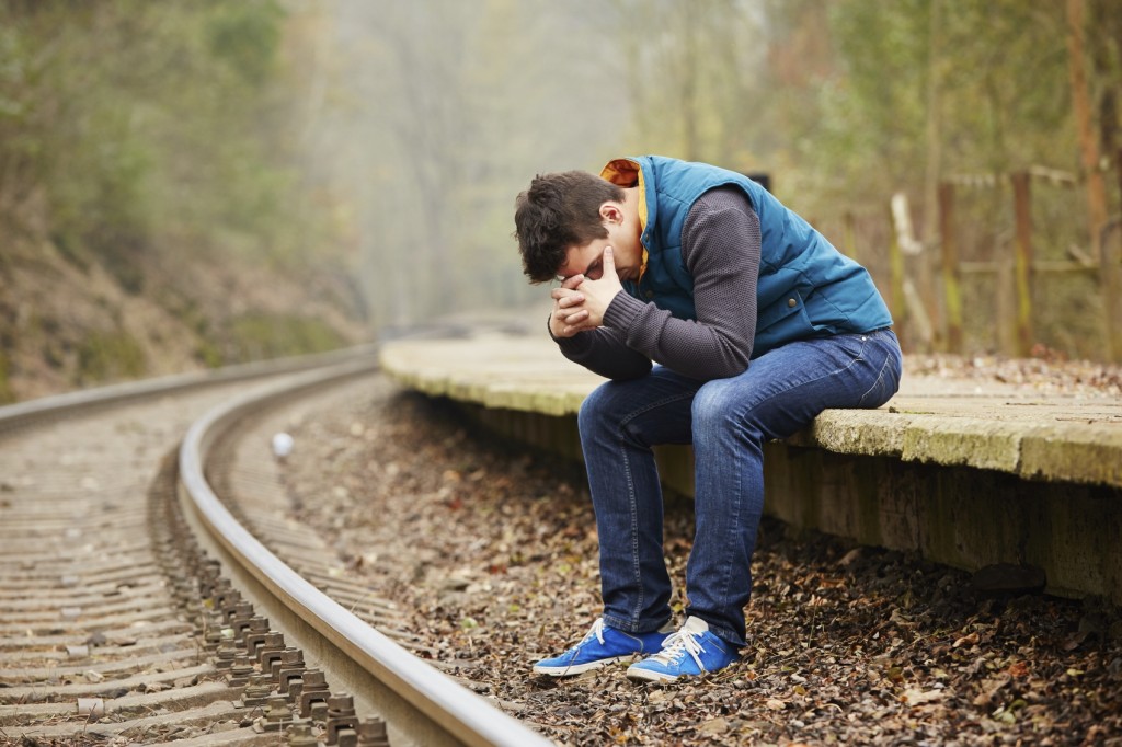 Sad young man at the railway station