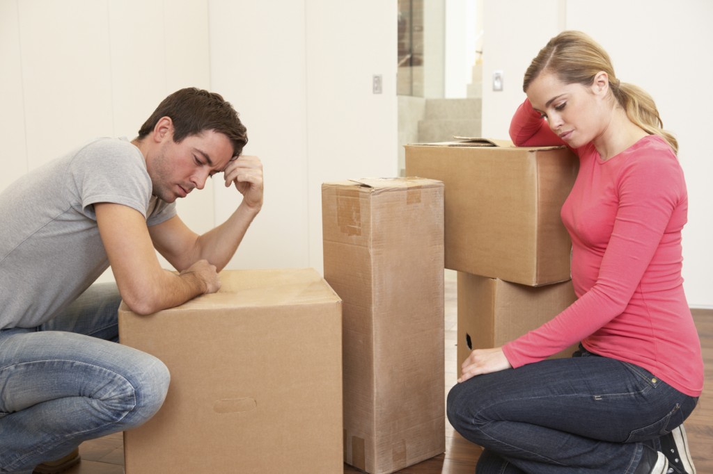 Young couple looking upset among boxes