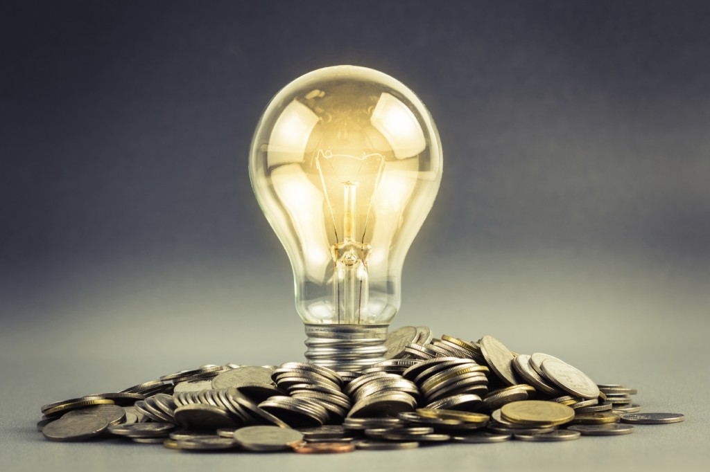 Light bulb and pile of coins