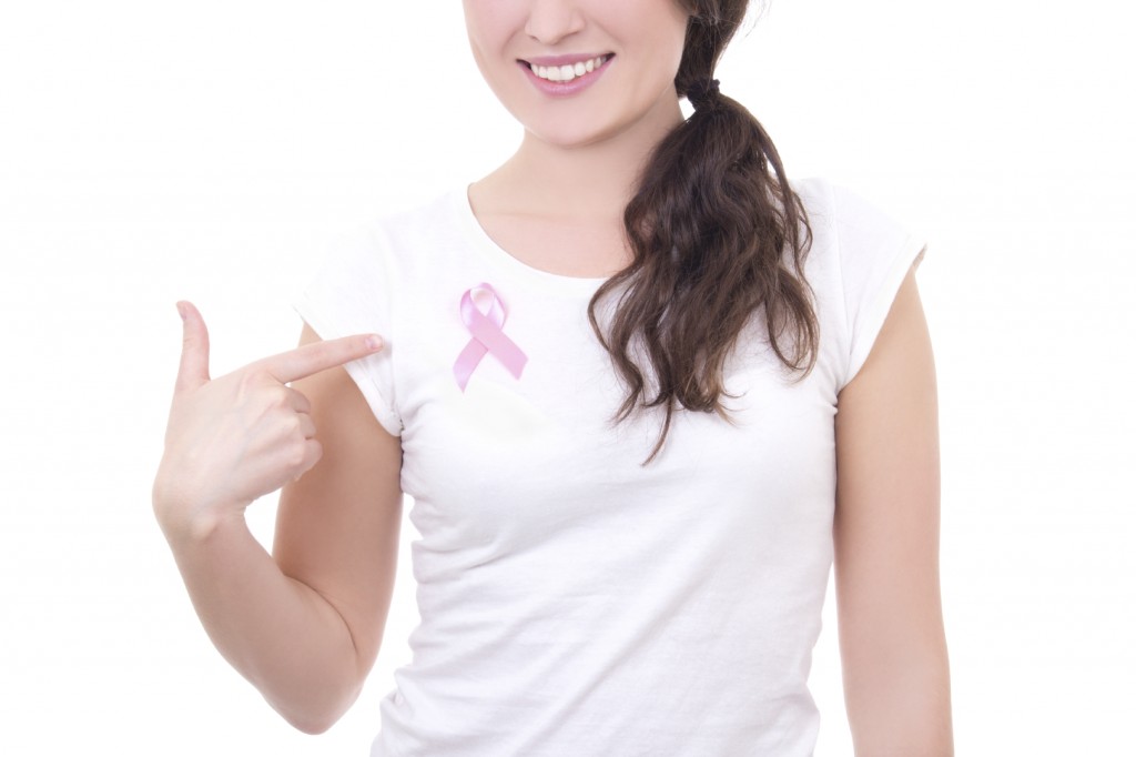 woman in white t-shirt with pink cancer ribbon on the breast