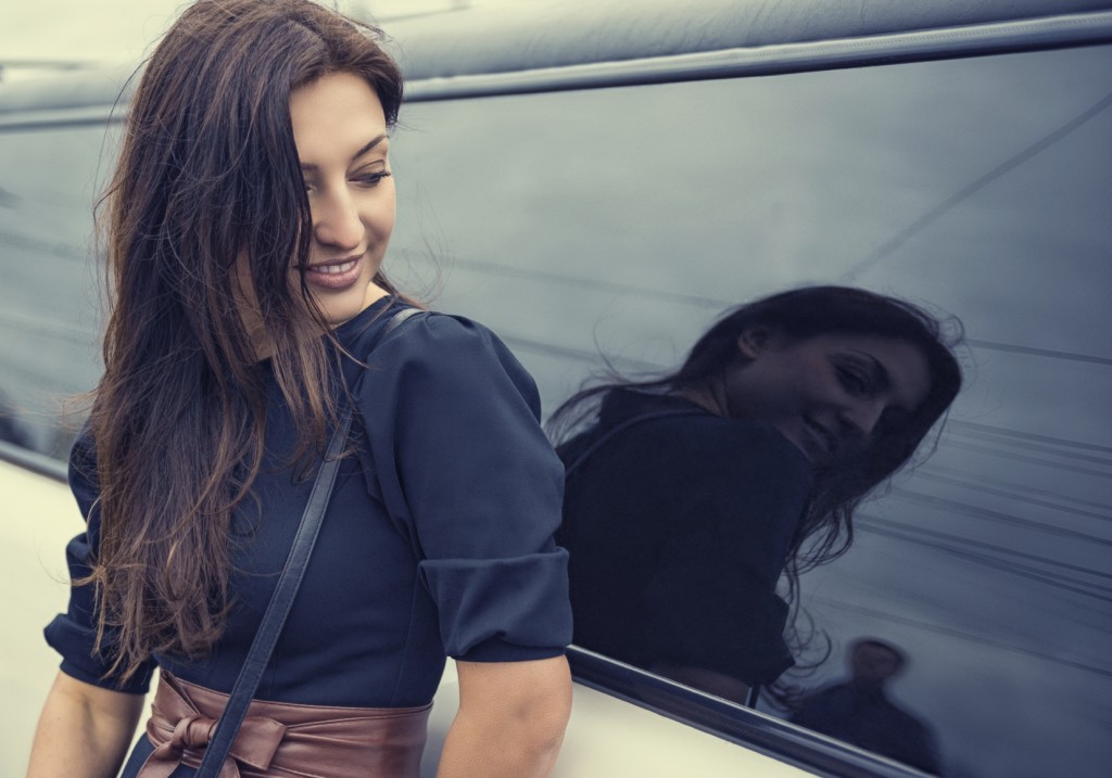 Woman looking at the man in reflection of automotive glass