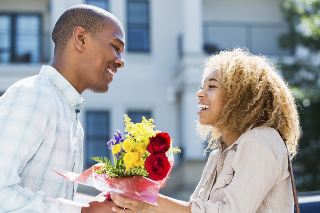 Young man gives flowers to girlfriend