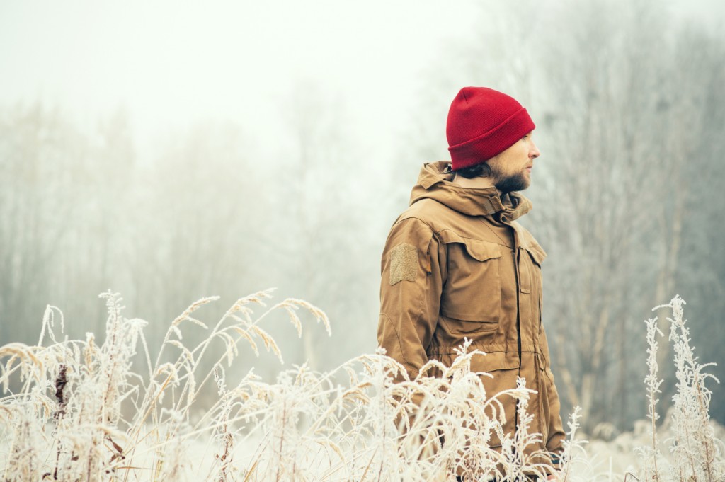 Young Man wearing winter hat clothing outdoor with foggy forest nature