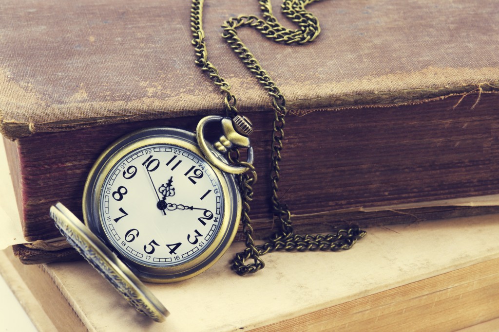 Vintage grunge still life with antique pocket watch, and old book