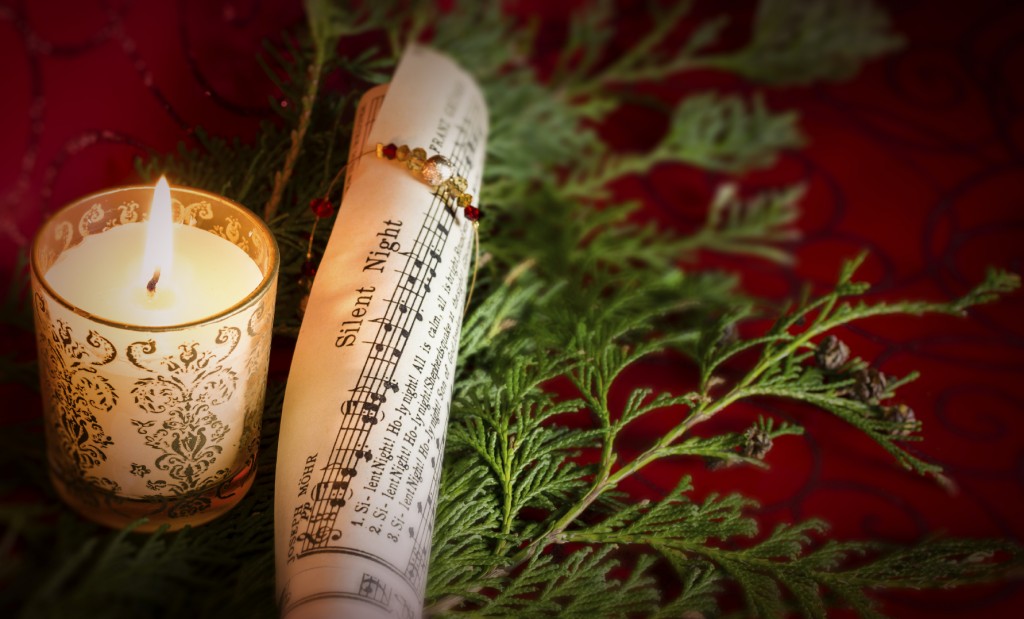 Christmas Carol music with candle and pine