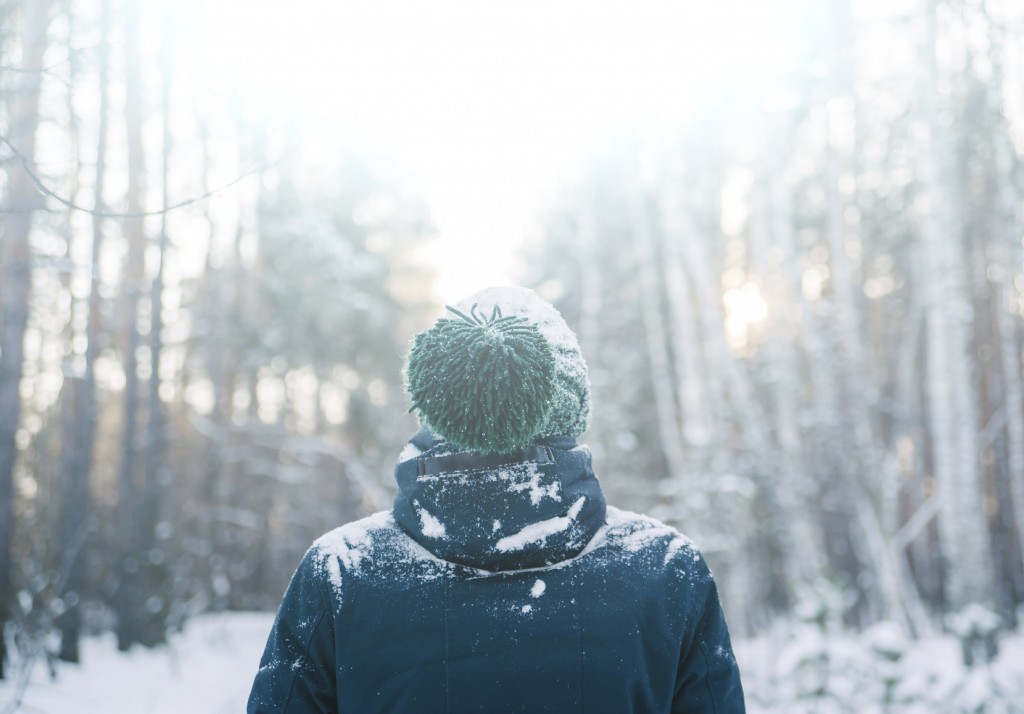 Hipster man in a winter snowy forest