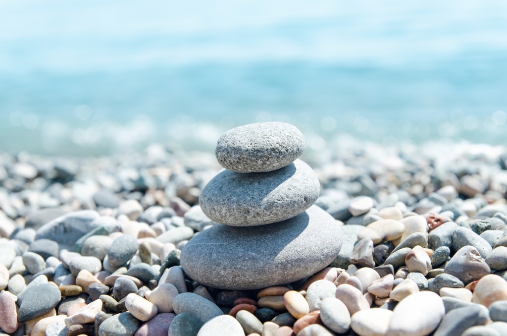 three stones on stack near sea