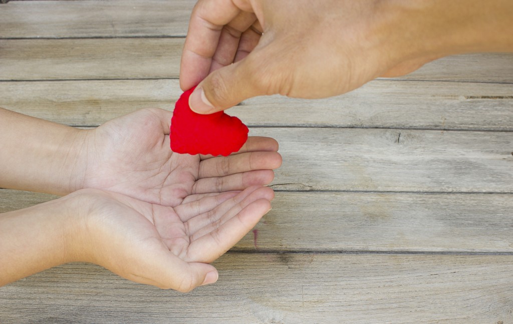 Concept of giving, giving a felt heart to another.