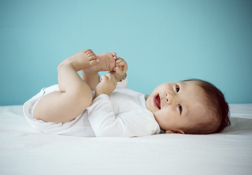 Portrait of a cute baby lying down on a bed,