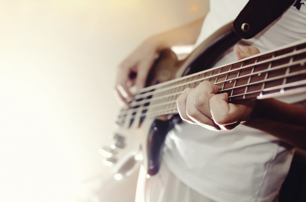 man practicing bass guitar close-up