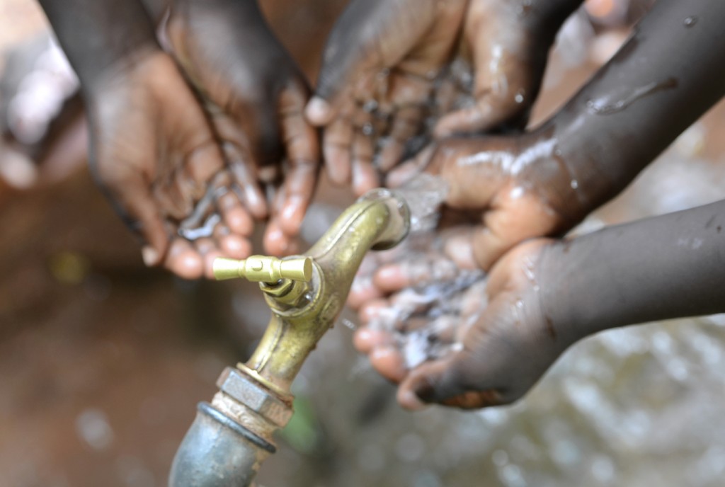 Hands of African Children Cupped under Tap Drinking Water