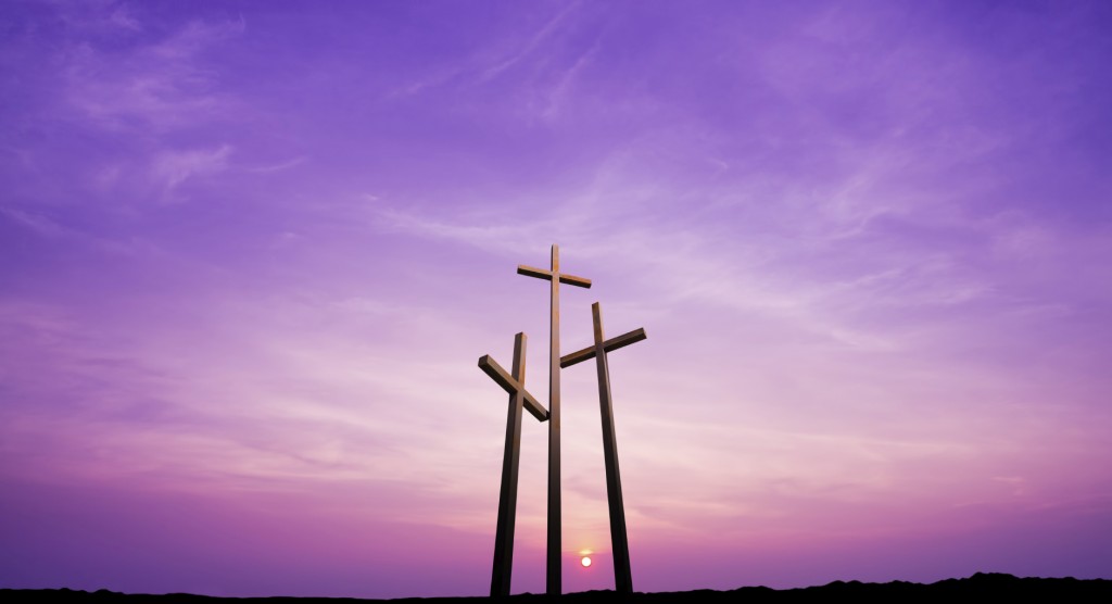 Three crosses on a hill over bright sky