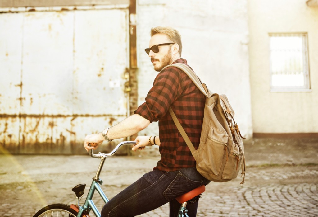 Hipster man on the bike, depth of field, Focus only on jeans and backpack