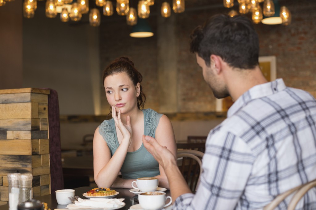 A young couple arguing in a cafe