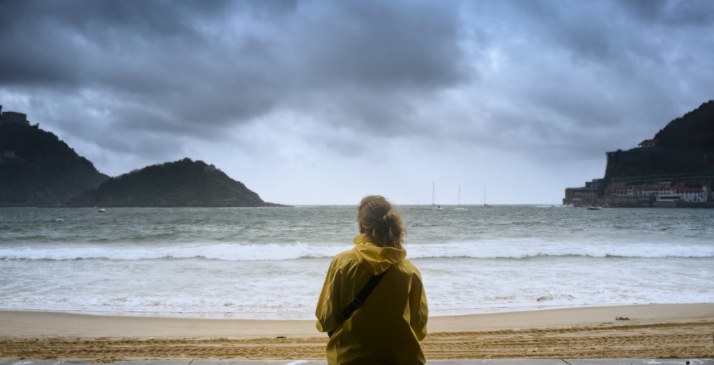 Young girl gazing at the ocean in San Sebastian