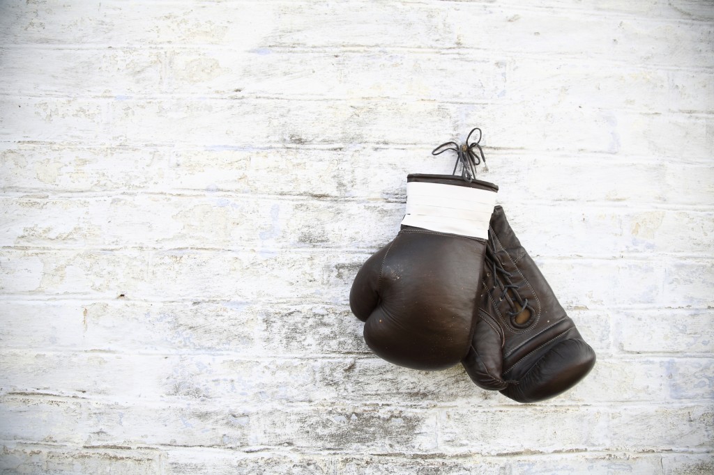 old boxing gloves nailed to the textured wall