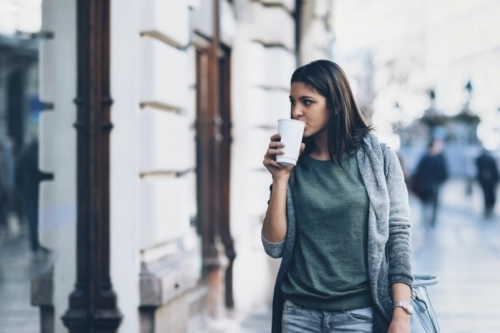 Teenage girl going shopping with take-away coffee