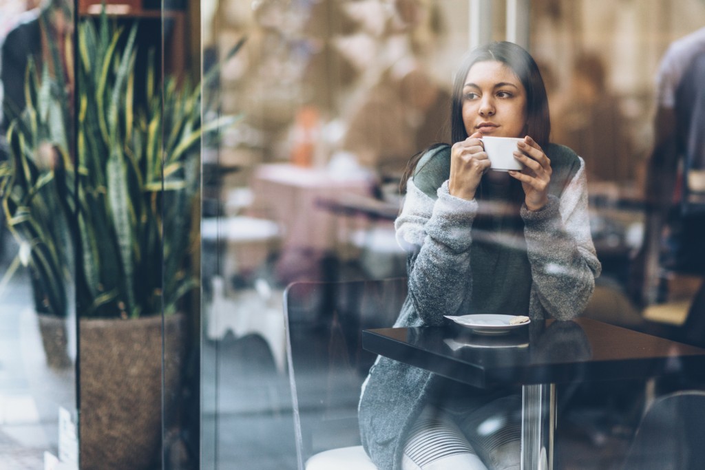 Young woman having coffee in urban cafeteria