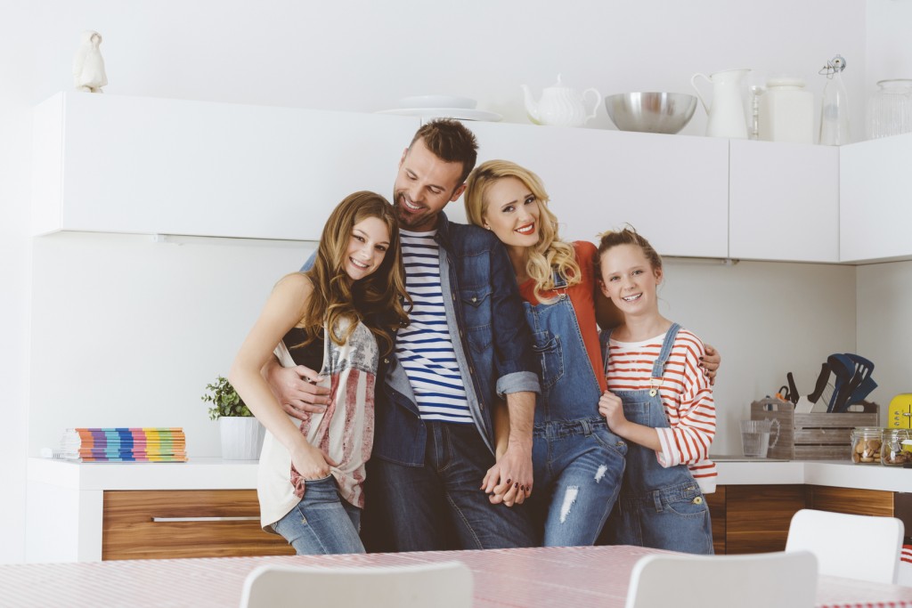 Happy family - mother, father and daughters at home
